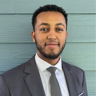 Samson Assefa wearing a dark suit and tie